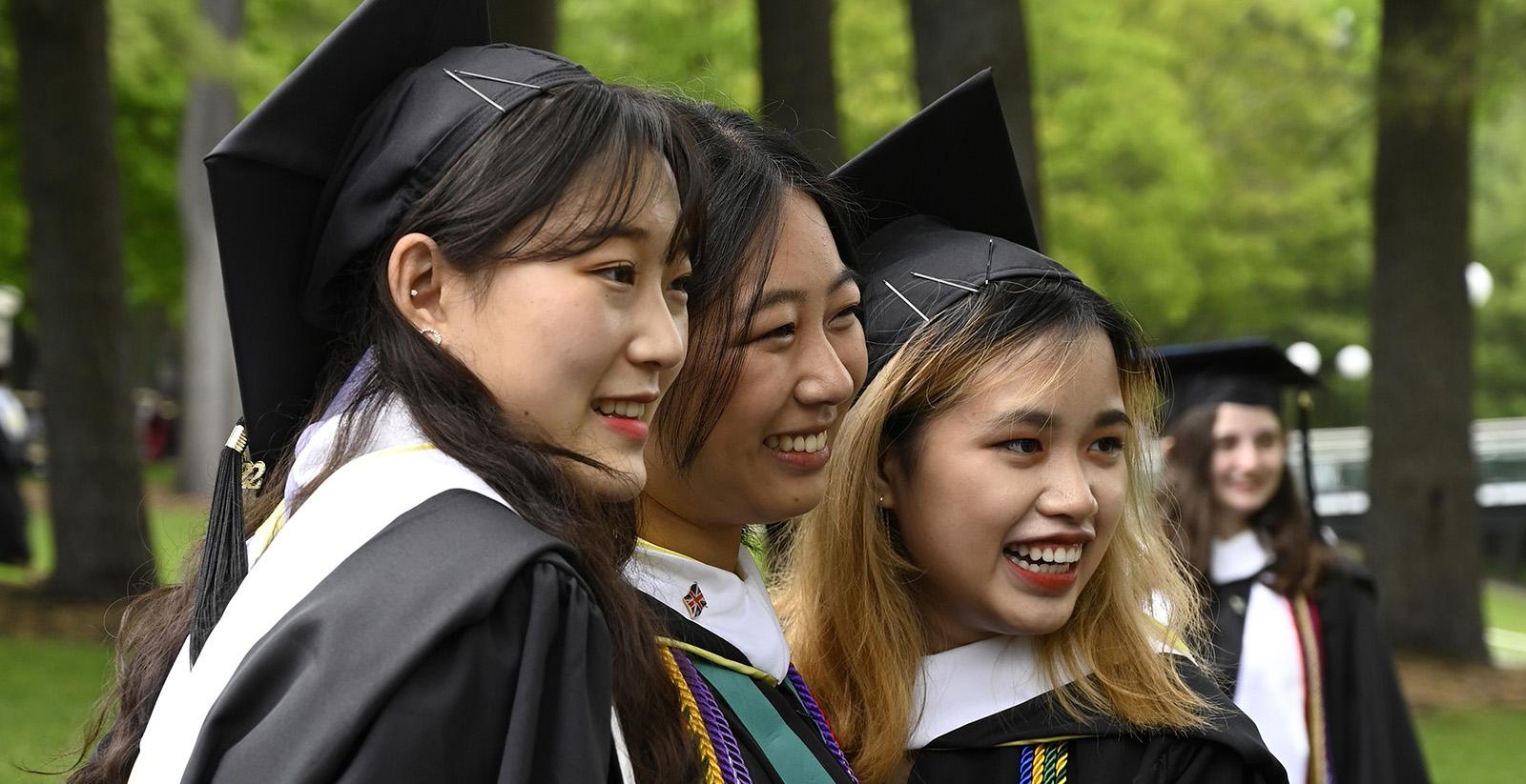 Three Skidmore graduates posing for a photo at commencement 2022